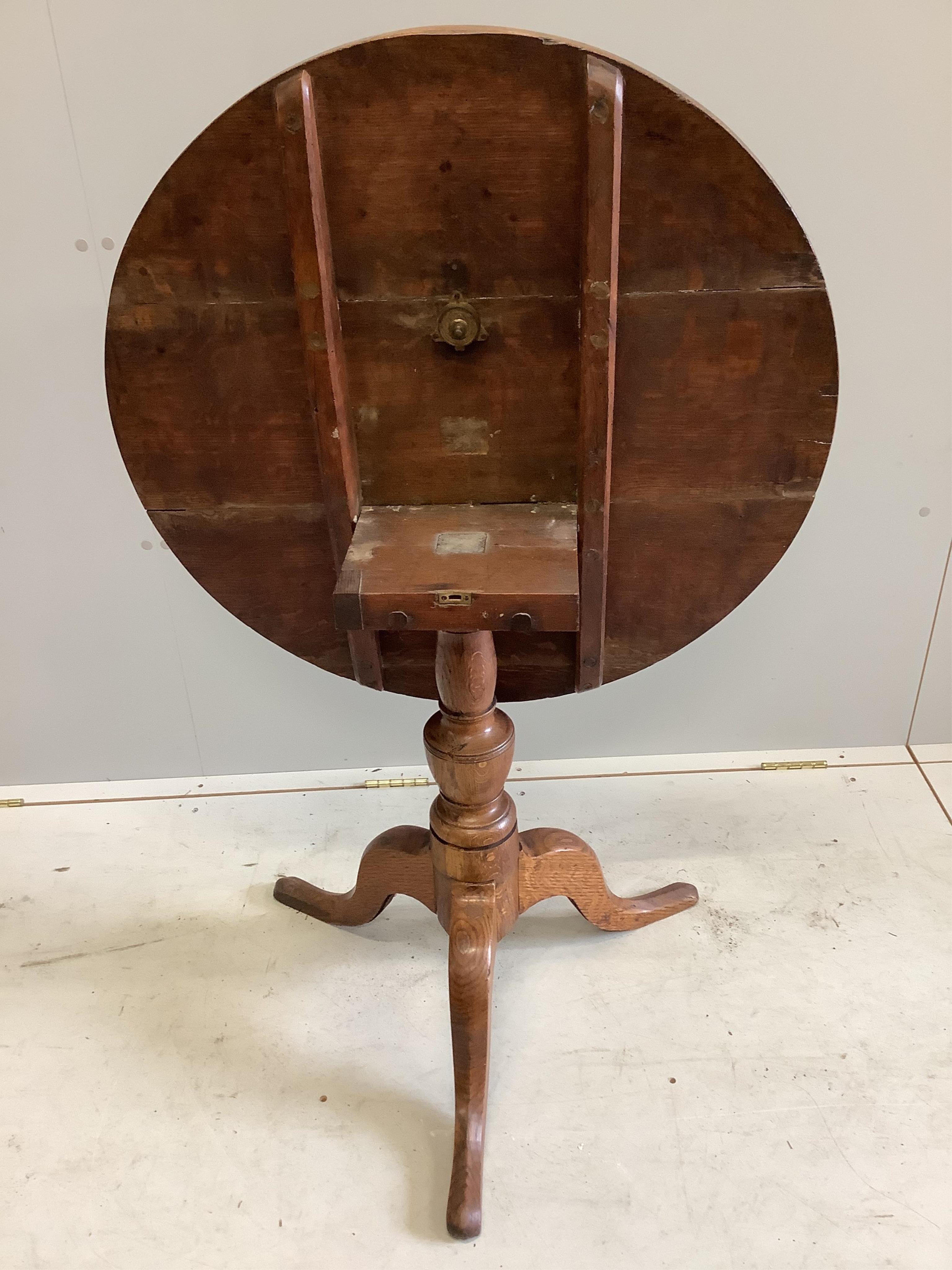 A George III oak tripod table, diameter 78cm, height 71cm. Condition - fair to good